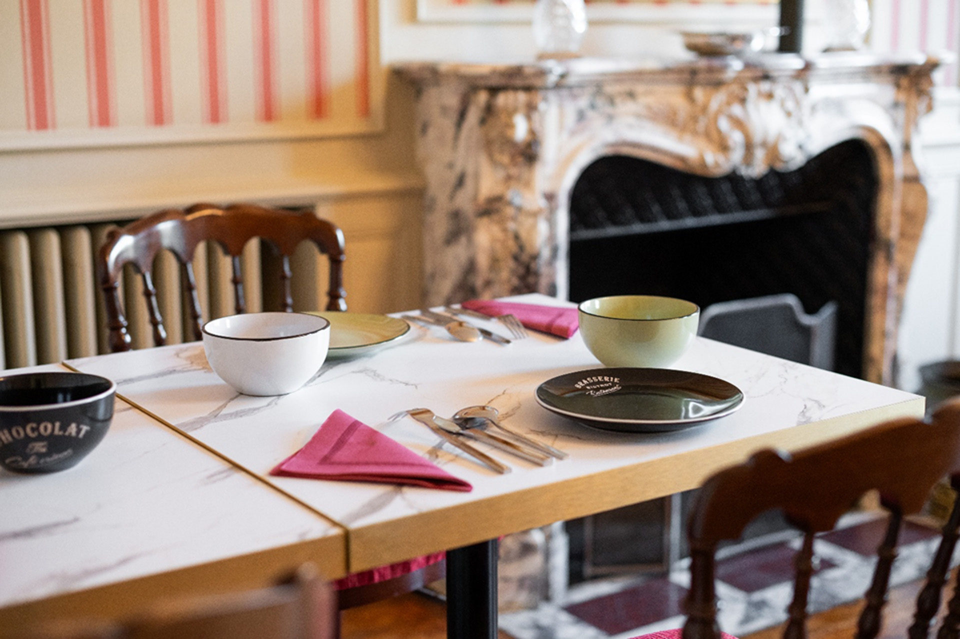 Une table de petit-déjeuner dressée avec des bols colorés en faïence bistrot aux Cordeliers, un hôtel de charme à Sarlat