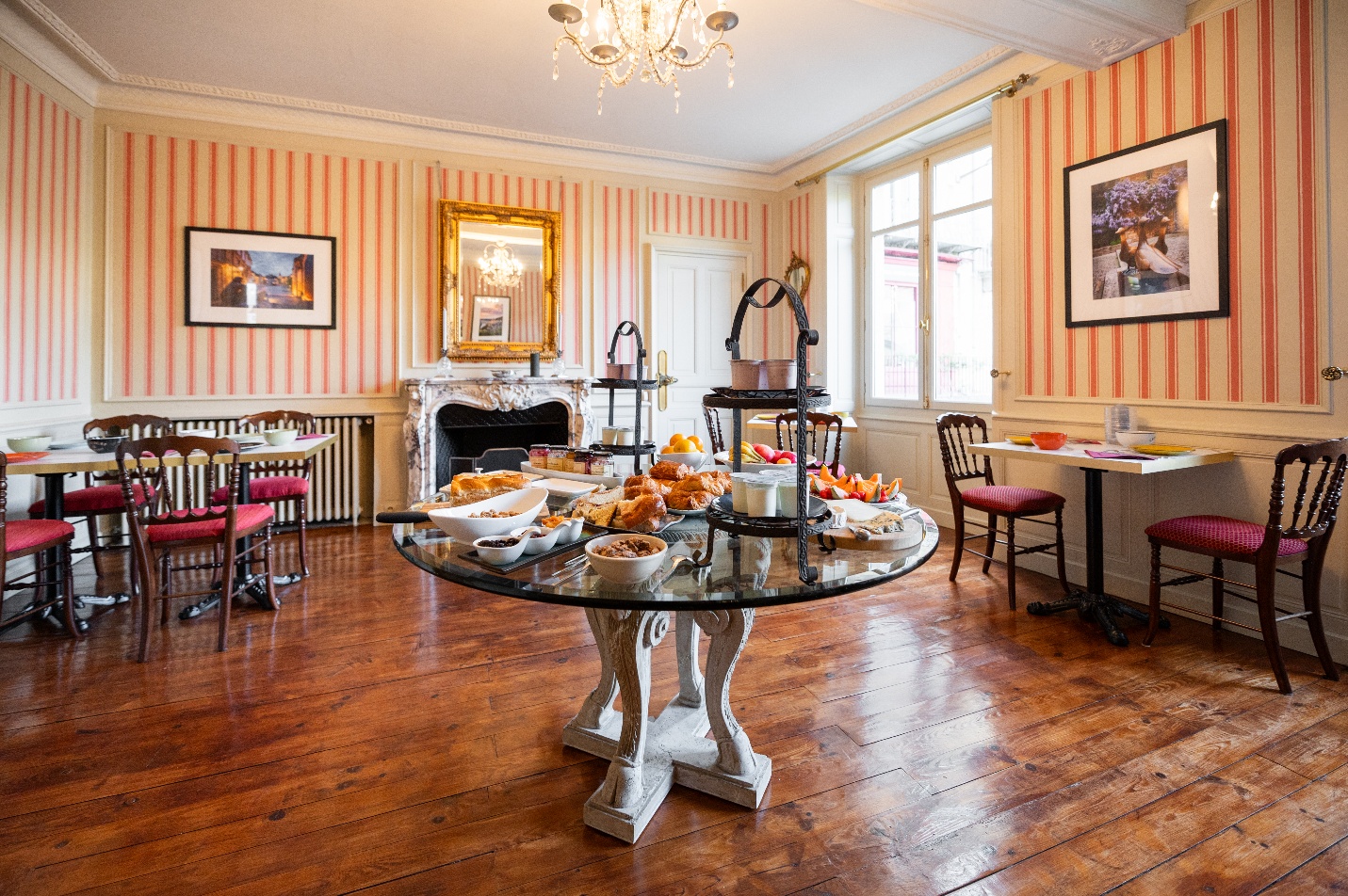 La salle de petit-déjeuner aux Cordeliers, un hôtel de charme à Sarlat, avec le buffet du jour disposé sur la table centrale